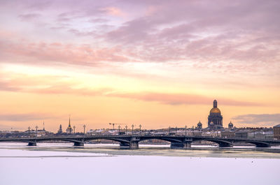 Bridge over river against cloudy sky