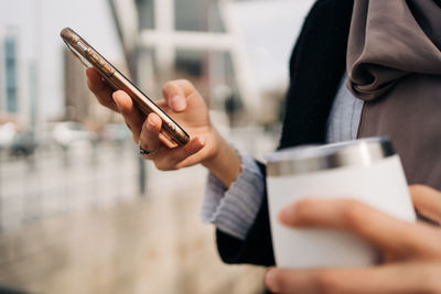 Midsection of man using mobile phone