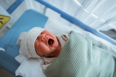 Portrait of cute baby girl lying on bed at home