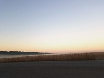 Scenic view of field against clear sky during sunset