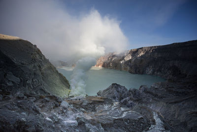 Smoke emitting from volcanic mountain against sky