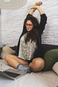 Young woman sitting on sofa at home