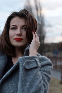 Portrait of young woman wearing warm clothing in city during winter