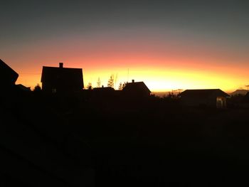 Silhouette cityscape against sky during sunset