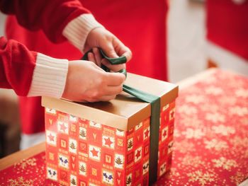 Close-up of man tying gift box at table