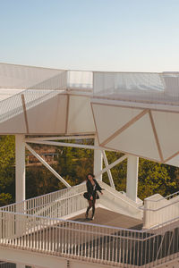 Young woman standing by railing