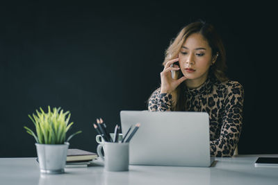 Young woman using smart phone on table