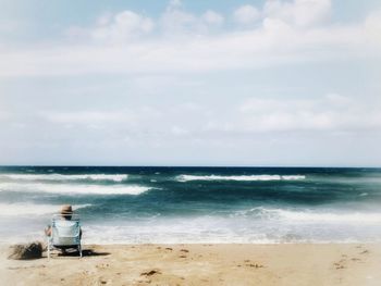 Rear view of man looking at sea against sky