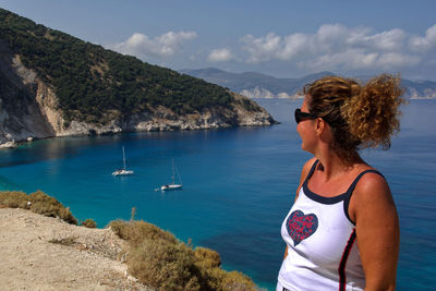 Rear view of woman looking at sea against mountain