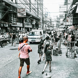 Rear view of people walking on street in city