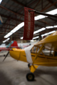 Close-up of yellow toy hanging on wood