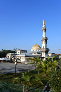 Church by building against clear blue sky