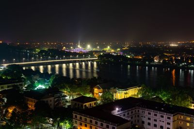 High angle view of illuminated buildings by river at night