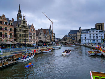 Boats in canal amidst buildings in city