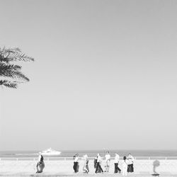 People on sea against clear sky