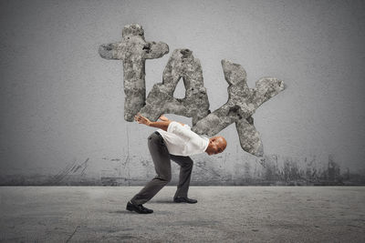 Full length of man standing against wall