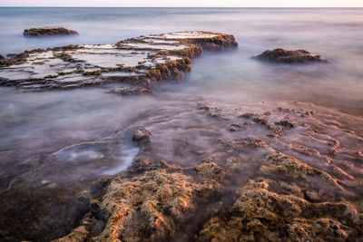 Aerial view of rocks on beach against sky