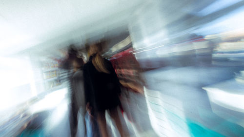 Blurred motion of people walking on road in city