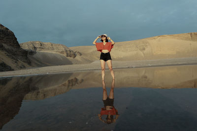 Full length of young woman standing in water