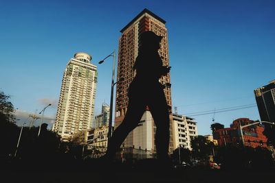 Low angle view of skyscrapers against clear blue sky