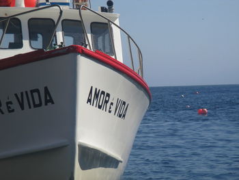 Close-up of ship moored on sea against clear sky