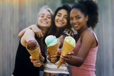 Portrait of beautiful female friends holding ice cream cones