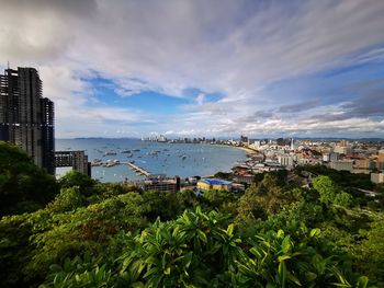 Scenic view of city by sea against sky