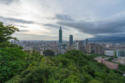 Buildings in city against cloudy sky