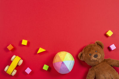 Directly above shot of colorful toys against red background
