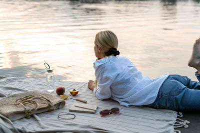 Young woman is resting in the evening by the lake.