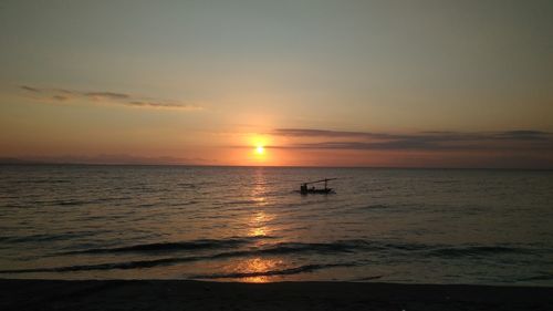 Silhouette people on beach against sky during sunset