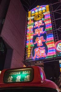 Low angle view of illuminated text on building at night