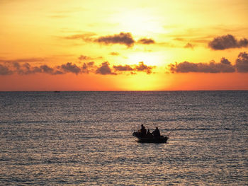 Silhouette sailboat sailing on sea against sky during sunset