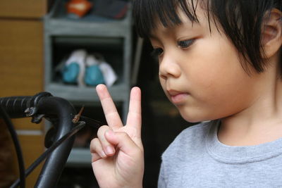 Close-up of boy gesturing while standing at home