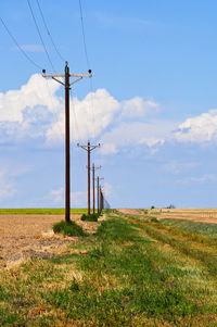 Electricity pylon on field against sky