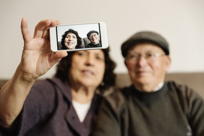 Portrait of man photographing with mobile phone