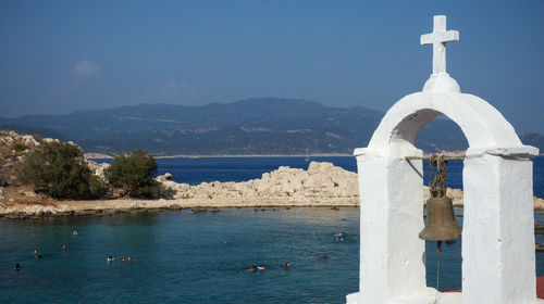 Sea by building against sky