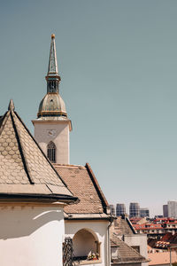 Roof of building in city against clear sky