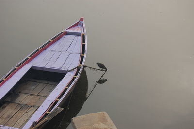 Boat moored in water against sky