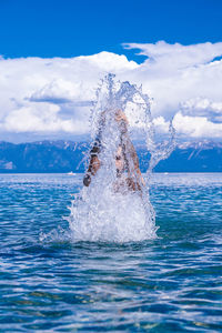 Water splashing in sea against sky