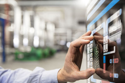 Man using touchscreen device in industrial plant