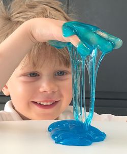 Smiling cute boy with hands in blue gel