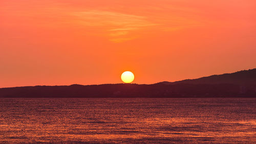 Scenic view of mountains and sea at sunset