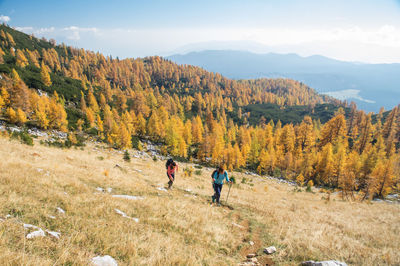 People walking on mountain road against sky