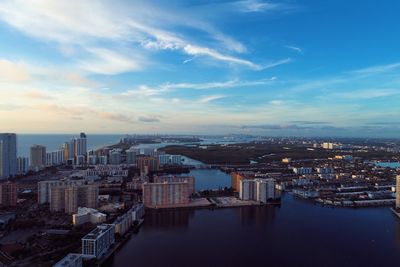 High angle view of river by buildings in city against sky