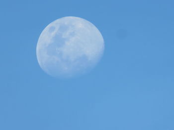 Low angle view of moon against clear blue sky