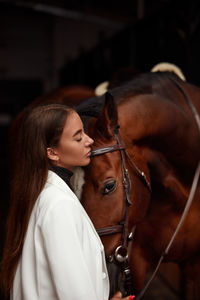 Young woman wearing sunglasses in stable