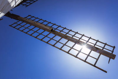 Low angle view of crane against clear blue sky