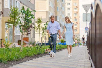 Couple with dog walking on footpath