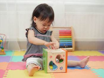 Baby girl playing with toys at home